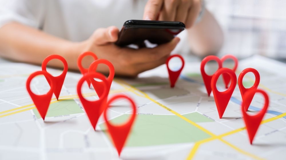 Person using phone on a mapping table | Feature | Auto Industry Update: Discovery Searches Turn One-Time Visitors into Lifetime Customers
