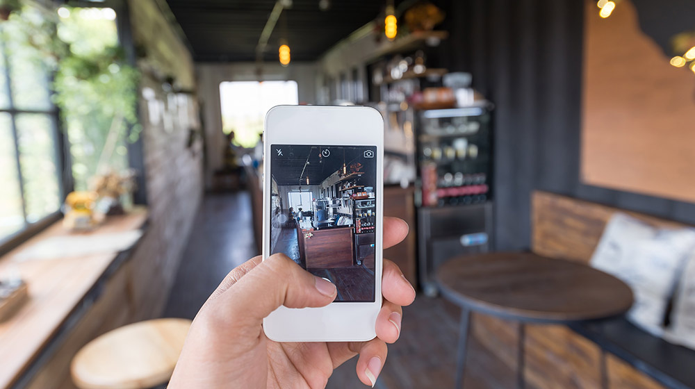 Person taking photo of the coffee shop | Feature | How Locl Helps You Combat Google Maps Marketing Challenges